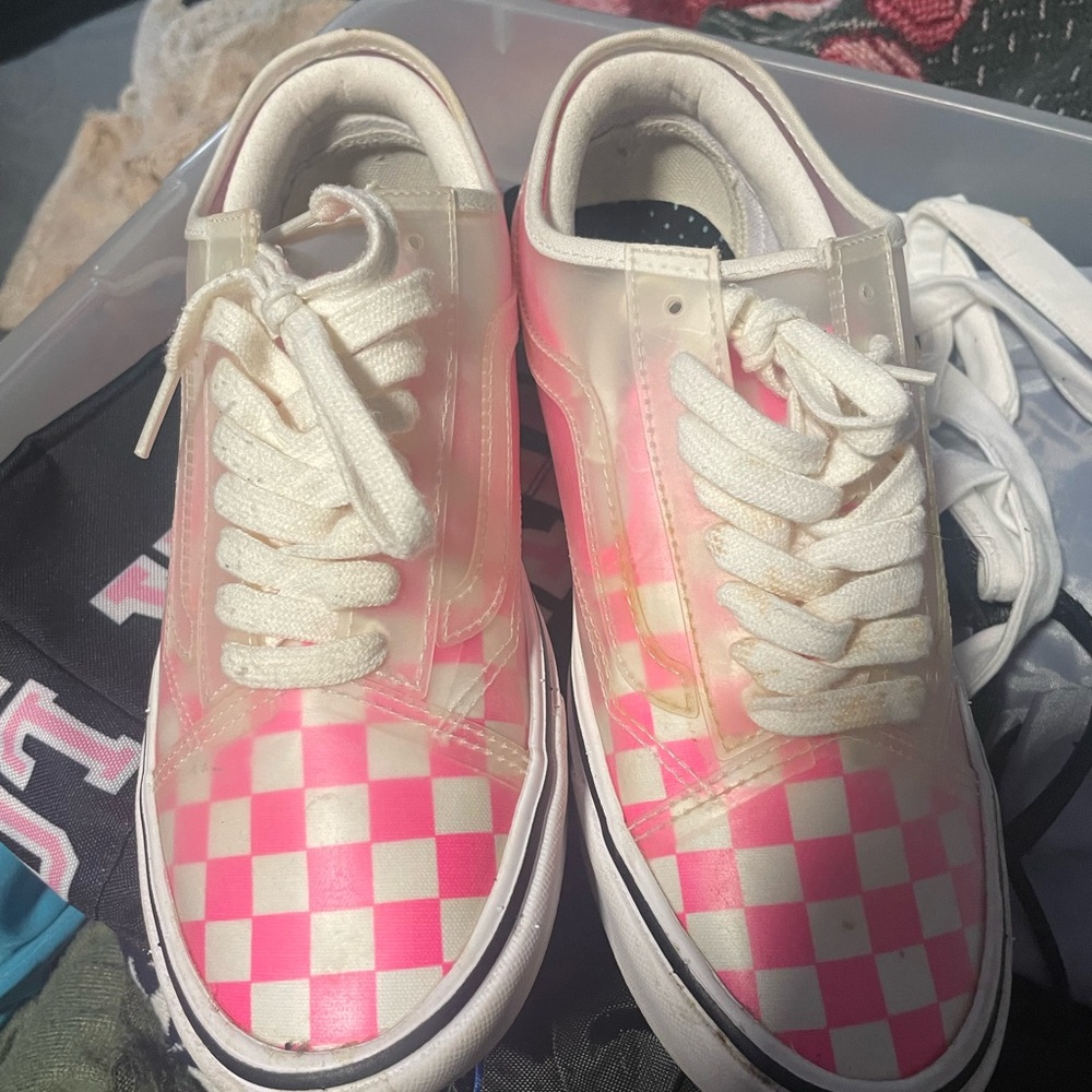Pink and white checkered vans , with a clear cover over them.